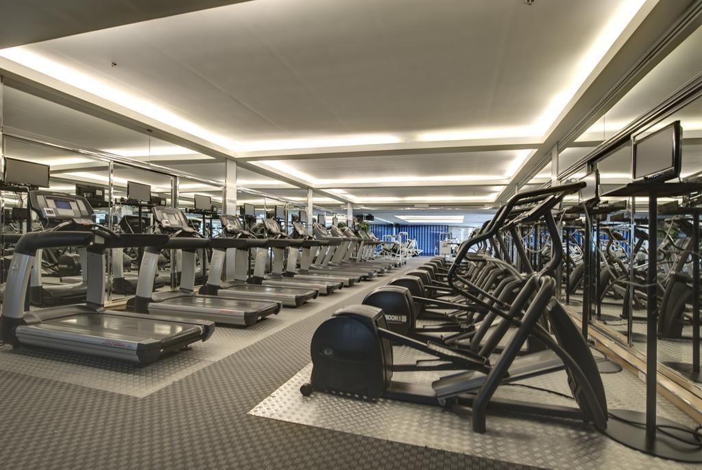 Pathumwan Princess Hotel - Sha Extra Plus Certified Bangkok Exterior foto The photo shows a modern gym interior with a spacious layout. On the left side, there are multiple treadmills lined up, and on the right side, there are more fitness machines, including elliptical trainers. The floor is covered with a textured mat, a